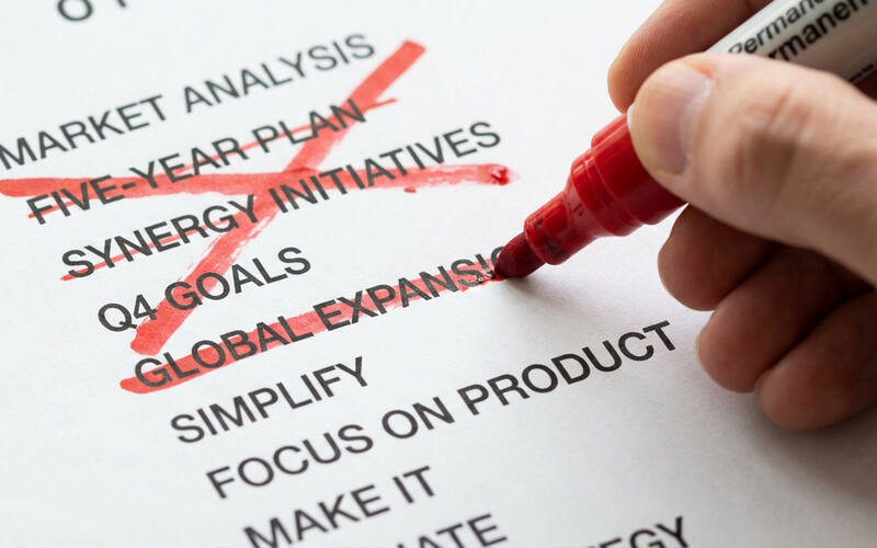 A bold red line crossing out items on a strategy list — the courage to say no
